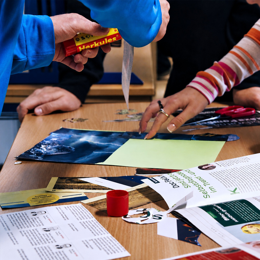 Workshops – gemeinsam Ideen entwickeln Mehrere Personen arbeiten gemeinsam an einem Workshop-Tisch mit Papier, Bildern, Schere und weiteren Materialien.